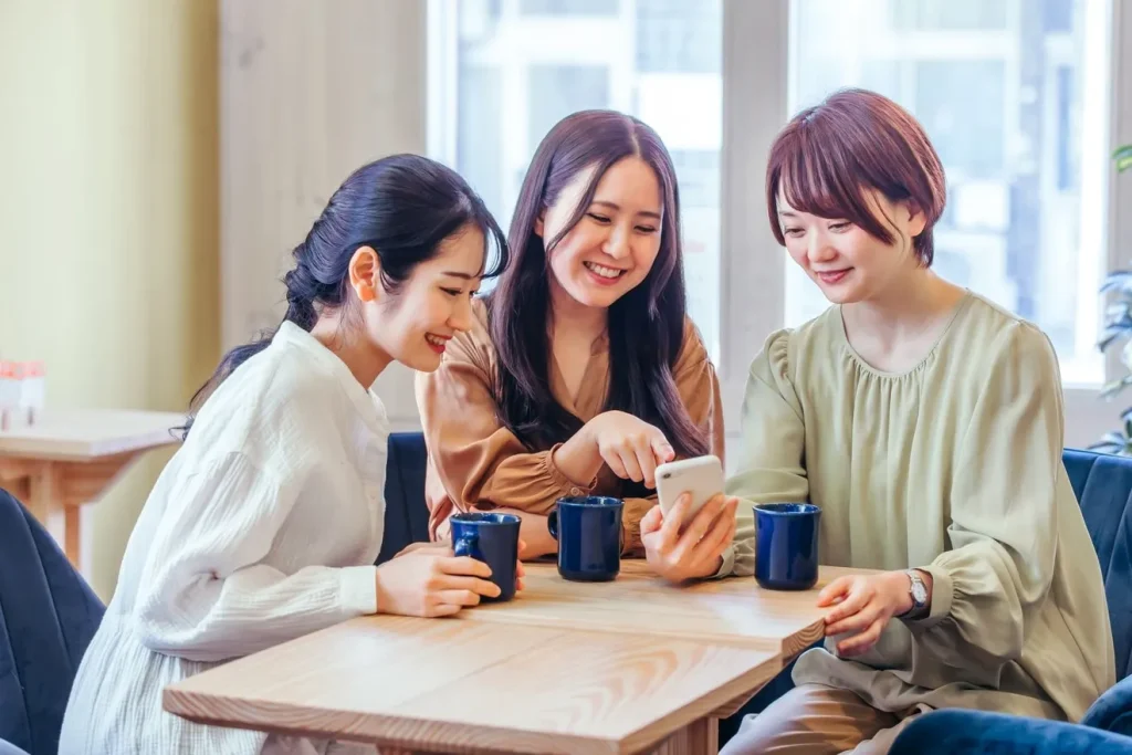 スマートフォンを見る笑顔の女性3人組