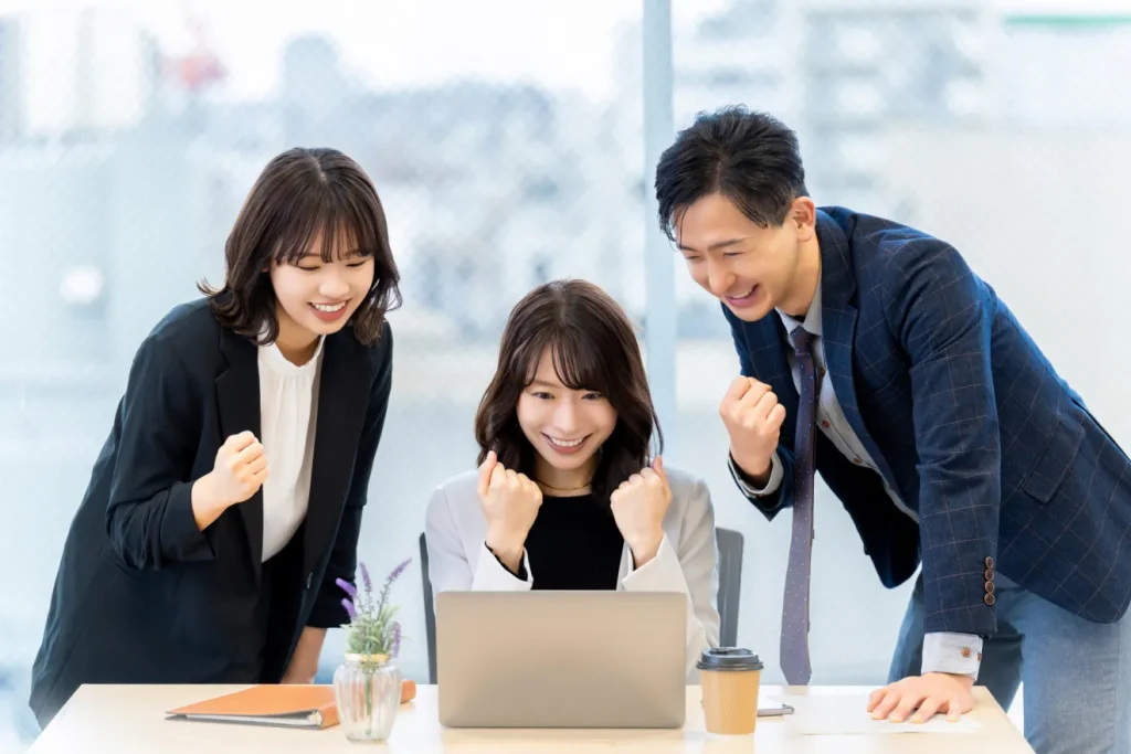 目的に合ったCMSで求人サイトが構築できて、喜んでいる3人のビジネスパーソン