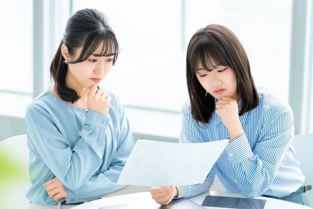 分析資料を見て悩んでいる2人の女性