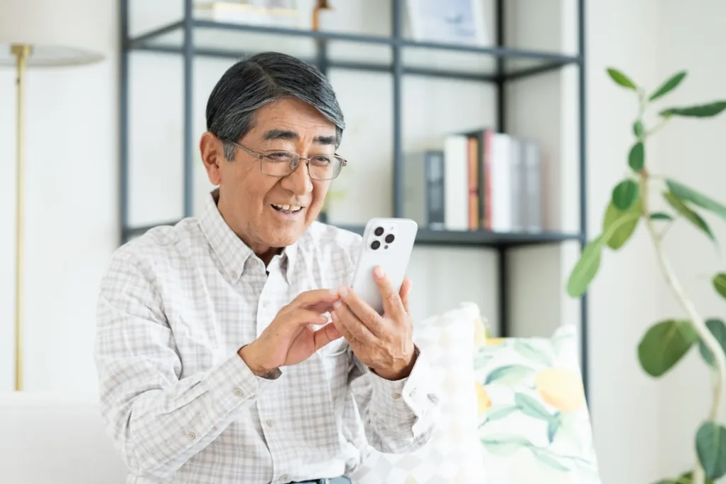 スマートフォンを操作してシニア向け求人を探す男性