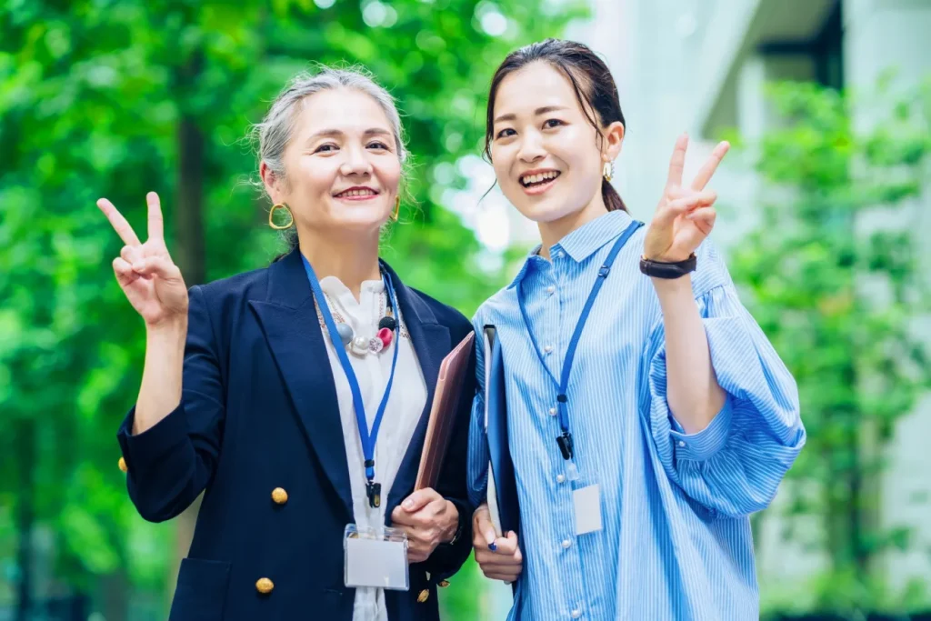 ピースサインをしているシニア女性と中年女性