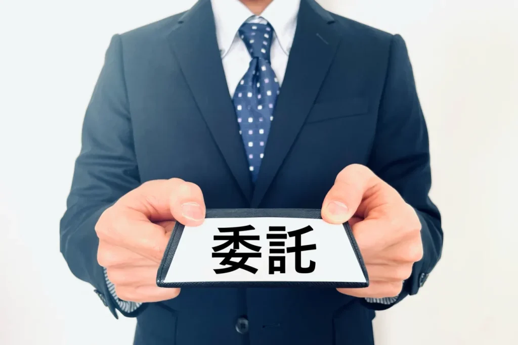 「委託」というカードを渡す人