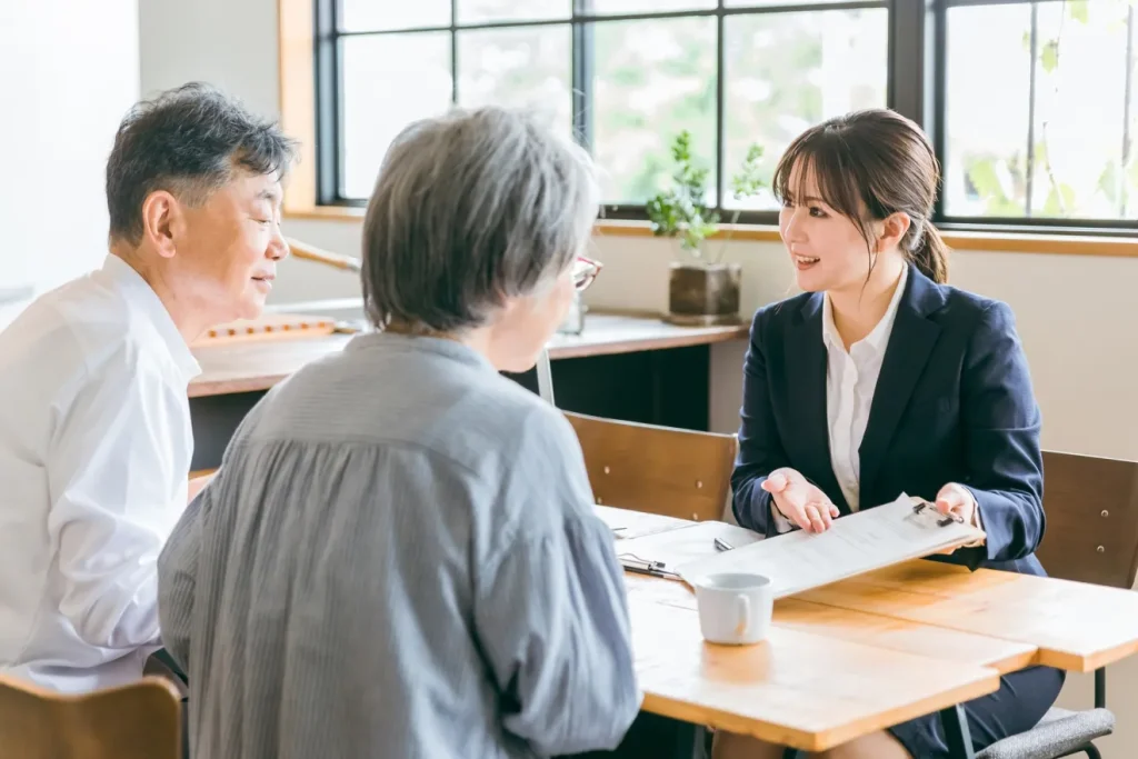 顧客の夫婦に提案をする広告代理店の女性