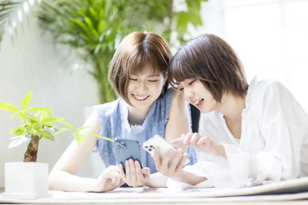 スマホを見ながら求人を選んでいる二人の女性